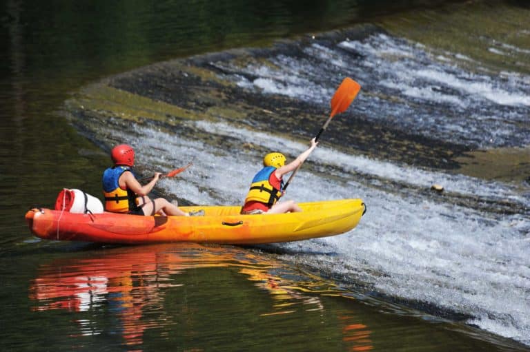 Deux femmes en canoë kayak dans un rapide du parcours sportif