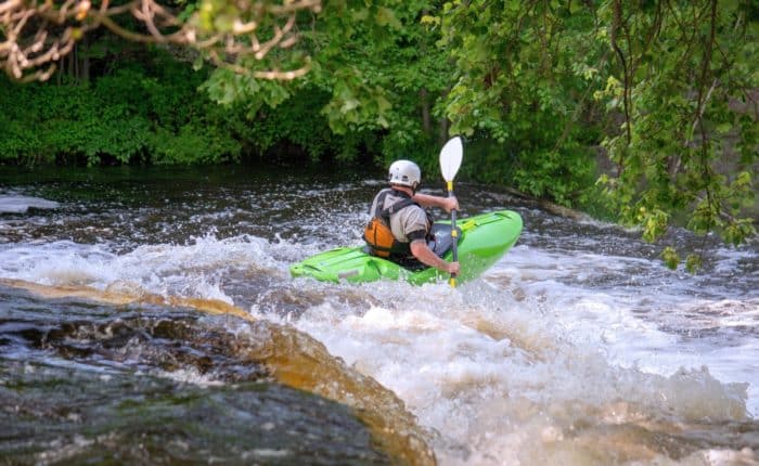 Un homme dans un rapide, canoë kayak parcours sportif