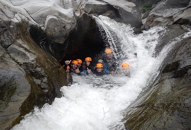 Groupe de personnes sous une cascade du canyon du Soucy