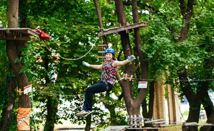 Femme sur une tyrolienne du parcours accrobranche adultes