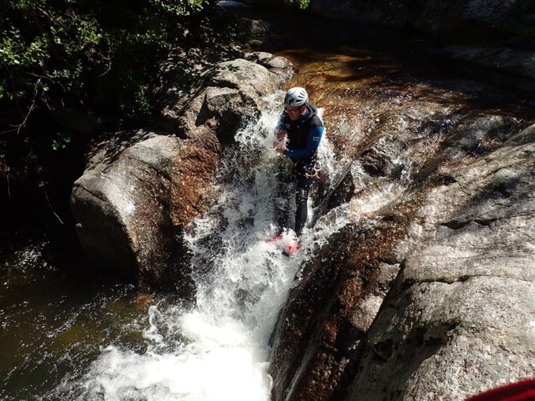 Un homme dans un petit toboggan du canyon de Tines