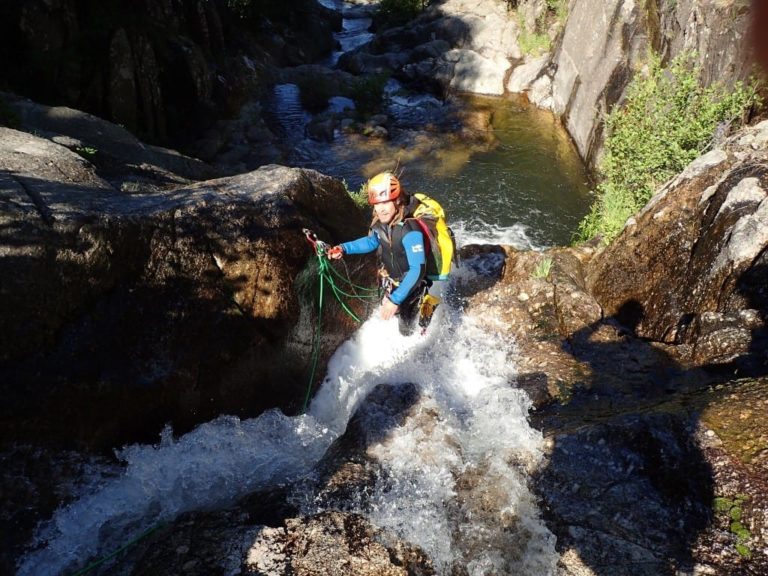Un guide installant une corde dans une cascade du canyon de Tines