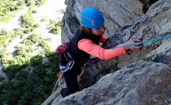 une femme escalade en grande voie au Thaurac