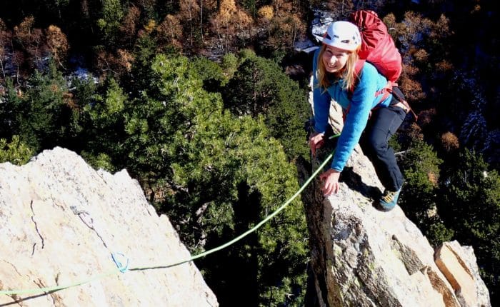 Jeune femme sur une arrête, lors de l'escalade d'une grande voie au Caroux