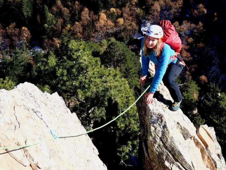 Jeune femme sur une arrête, lors de l'escalade d'une grande voie au Caroux