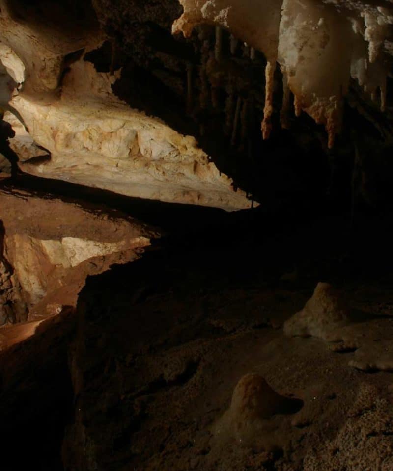 Un homme dans une des cavités de la grotte de genevaux
