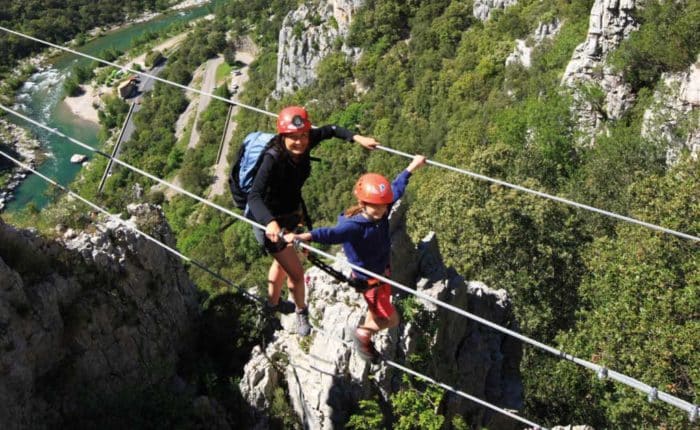 une famille sur le pont de singe de la Via Ferrata du Thaurac