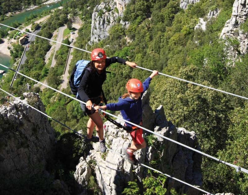 une famille sur le pont de singe de la Via Ferrata du Thaurac