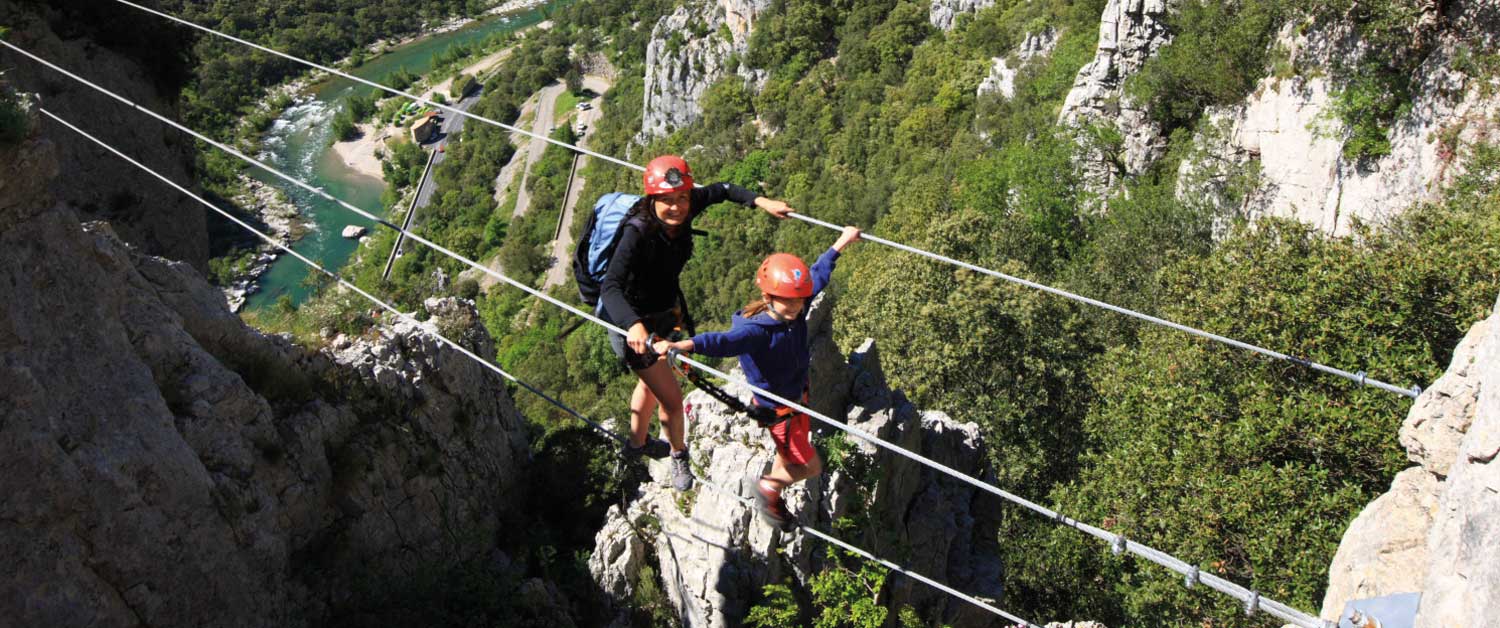 une famille sur le pont de singe de la Via Ferrata du Thaurac