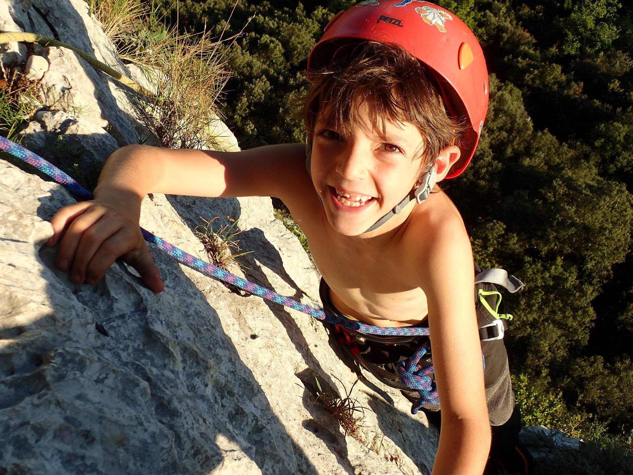 Un garçon souriant qui escalade les falaises du Thaurac